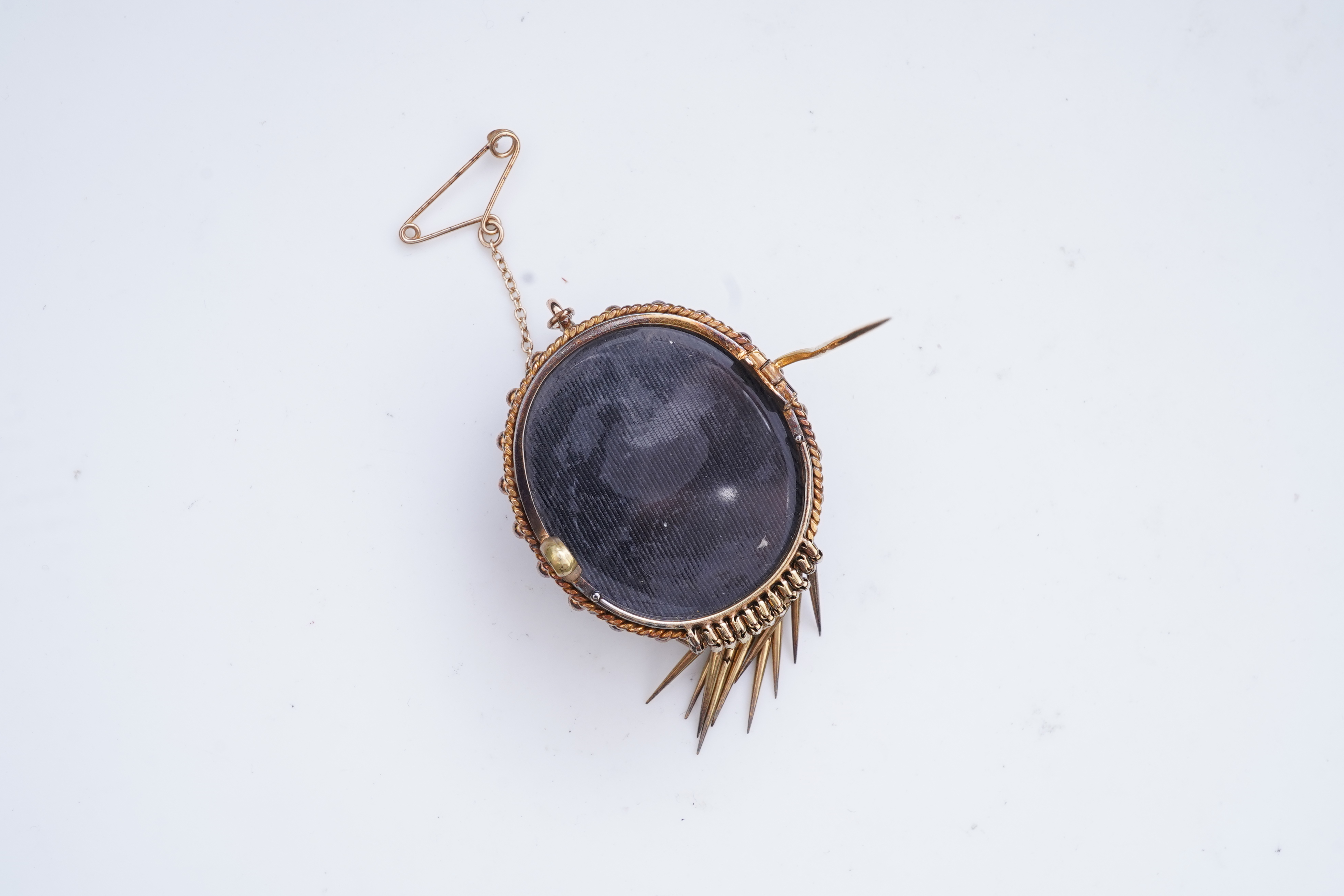 A Victorian garnet and enamel brooch, mid 19th century